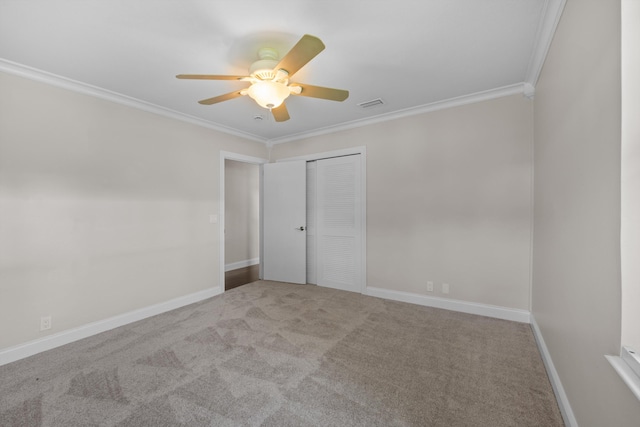 carpeted spare room with ornamental molding, a ceiling fan, and baseboards