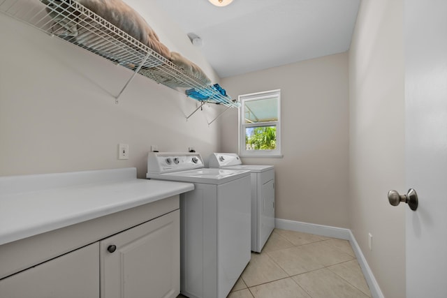 laundry area featuring separate washer and dryer, light tile patterned floors, and baseboards