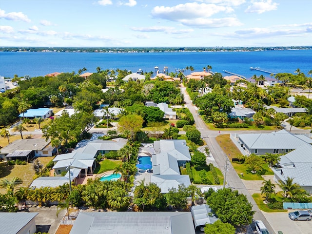 aerial view of residential area with a nearby body of water and a pool area