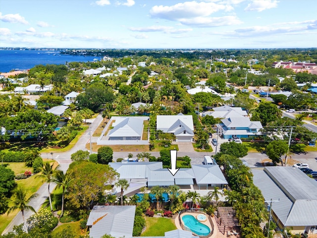 aerial view of residential area featuring a large body of water and a pool area
