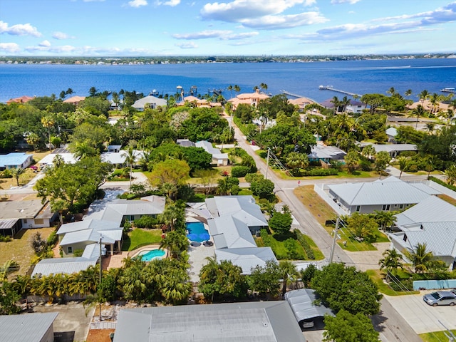 aerial view of residential area with a nearby body of water and a pool area