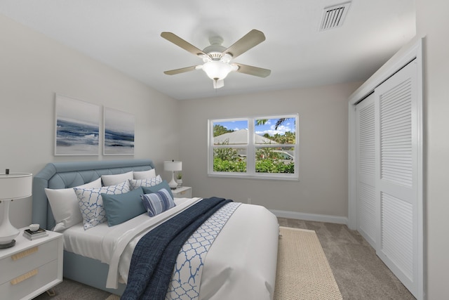 carpeted bedroom with a closet, baseboards, and ceiling fan
