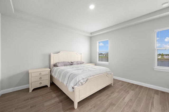 bedroom with baseboards, recessed lighting, and wood finished floors