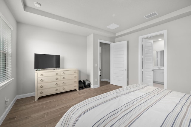 bedroom with baseboards, visible vents, multiple windows, and wood tiled floor