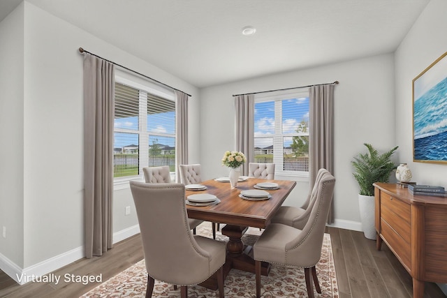 dining area with baseboards and wood finished floors