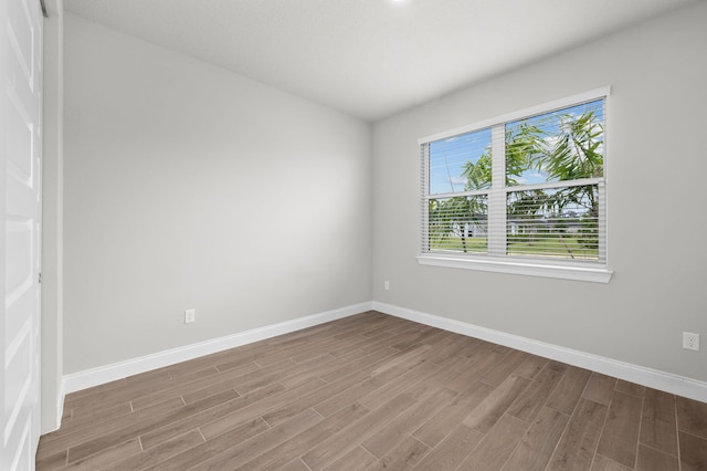unfurnished room with baseboards and wood finished floors