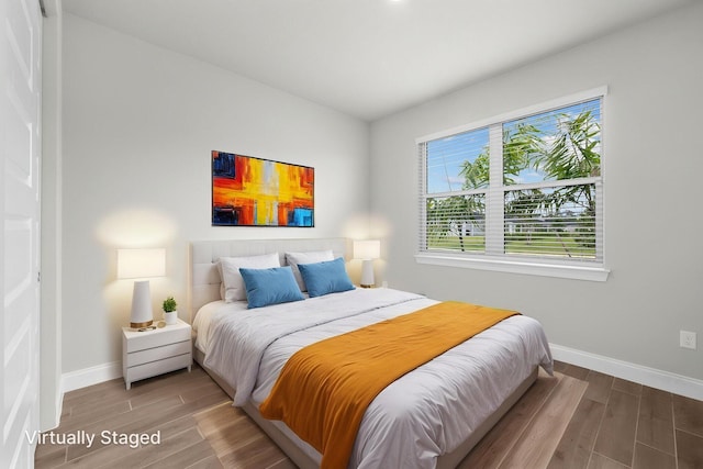bedroom with baseboards and wood finished floors