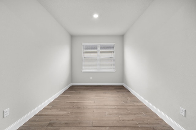 empty room with baseboards and wood finished floors