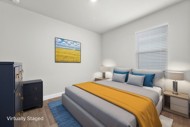 bedroom with baseboards and wood finished floors