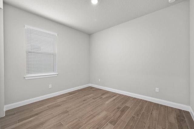 unfurnished room featuring baseboards and wood finished floors