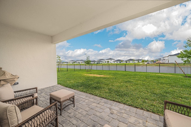 view of patio / terrace with a water view, a residential view, and a fenced backyard