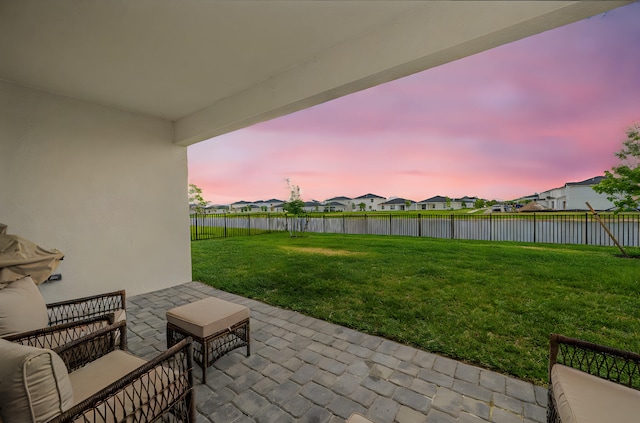 view of patio with a water view, a fenced backyard, and a residential view