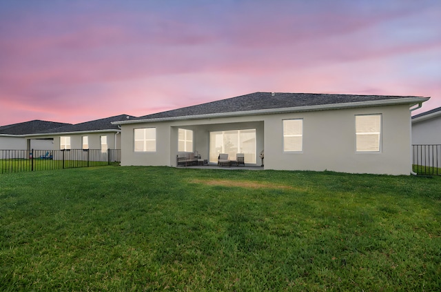 back of house with a lawn, a fenced backyard, a patio area, and stucco siding