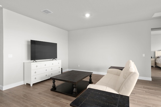 living area featuring baseboards, recessed lighting, wood finished floors, and visible vents