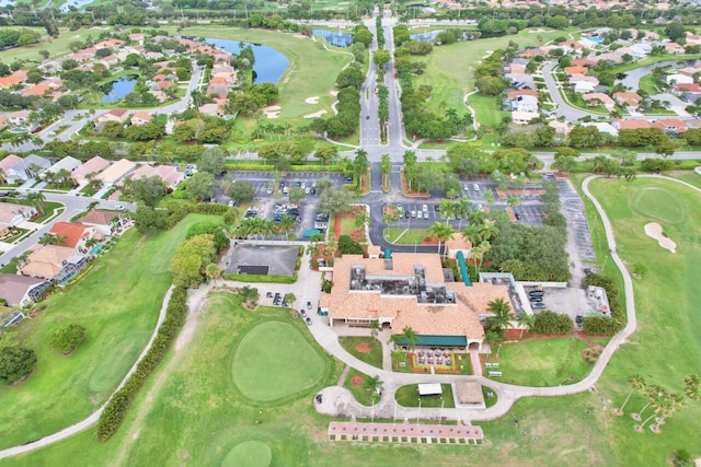 drone / aerial view with a water view, golf course view, and a residential view
