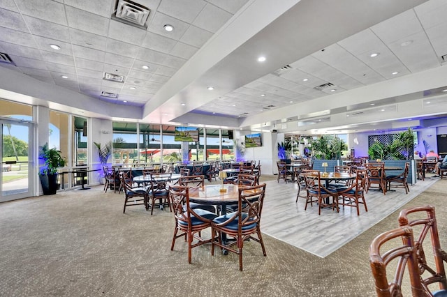 carpeted dining room with a drop ceiling and visible vents