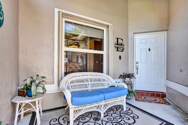 property entrance featuring a porch and stucco siding