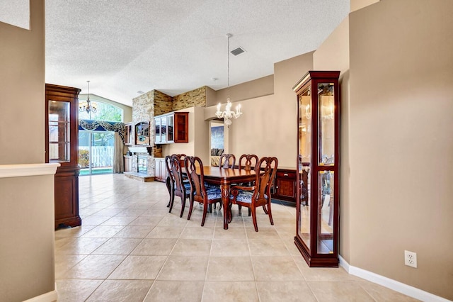 dining room with light tile patterned flooring, a textured ceiling, a notable chandelier, and baseboards