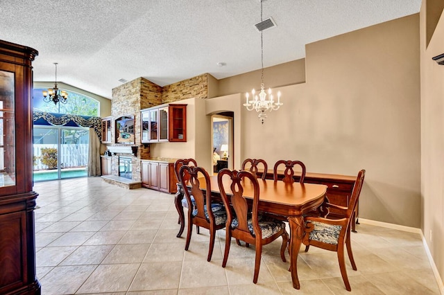 dining room with a textured ceiling, a notable chandelier, light tile patterned floors, and visible vents