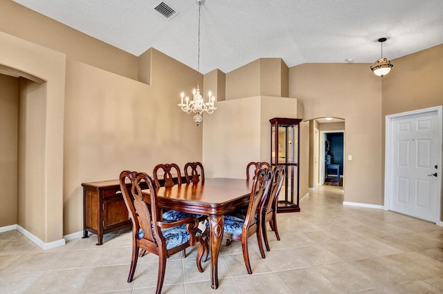 dining space featuring arched walkways, a notable chandelier, visible vents, and light tile patterned floors