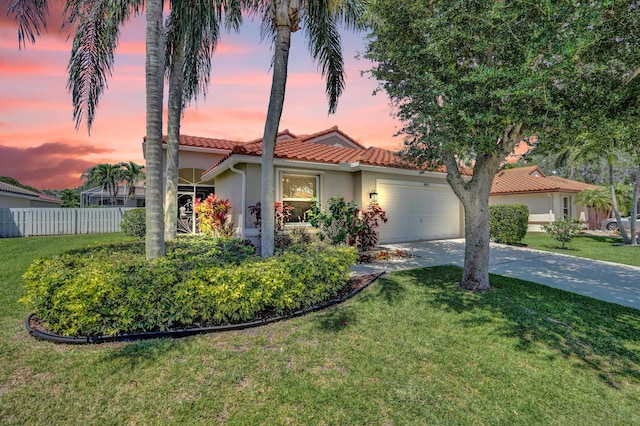 mediterranean / spanish-style house with fence, stucco siding, an attached garage, driveway, and a tile roof