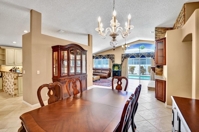 dining room with a textured ceiling, a chandelier, light tile patterned floors, and vaulted ceiling
