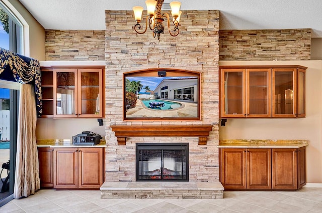 unfurnished living room featuring light tile patterned floors, a fireplace, a textured ceiling, and a notable chandelier