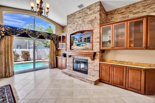unfurnished living room with a textured ceiling, light tile patterned floors, and a chandelier