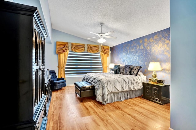 bedroom with ceiling fan, light wood-style floors, a textured ceiling, baseboards, and lofted ceiling