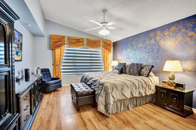 bedroom featuring light wood finished floors, a textured ceiling, a ceiling fan, baseboards, and vaulted ceiling