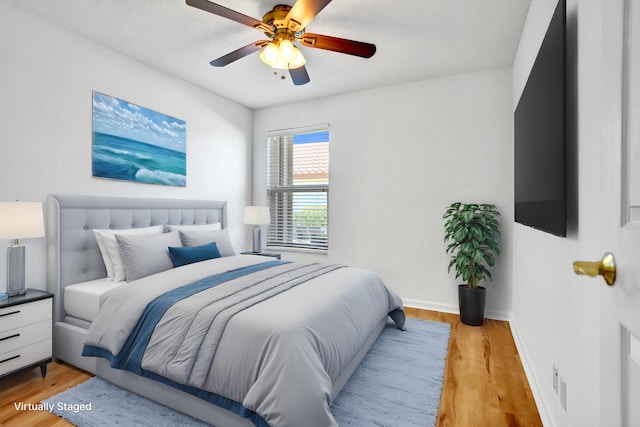 bedroom featuring light wood-type flooring, baseboards, and ceiling fan