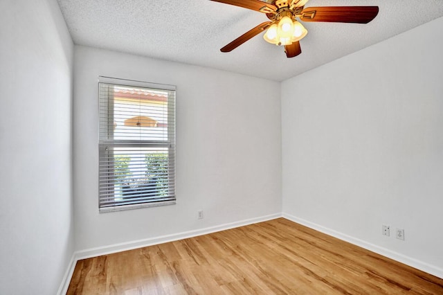 spare room featuring a ceiling fan, baseboards, a textured ceiling, and light wood-style floors