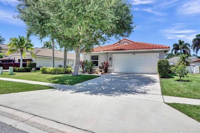 mediterranean / spanish-style home featuring a garage, a front lawn, stucco siding, driveway, and a tile roof