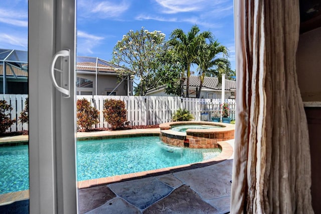 view of swimming pool with a patio, fence, and a pool with connected hot tub