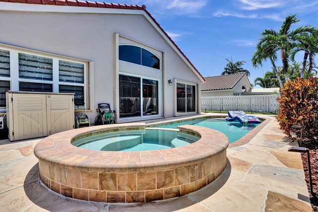 view of swimming pool featuring fence, a fenced in pool, an in ground hot tub, and a patio