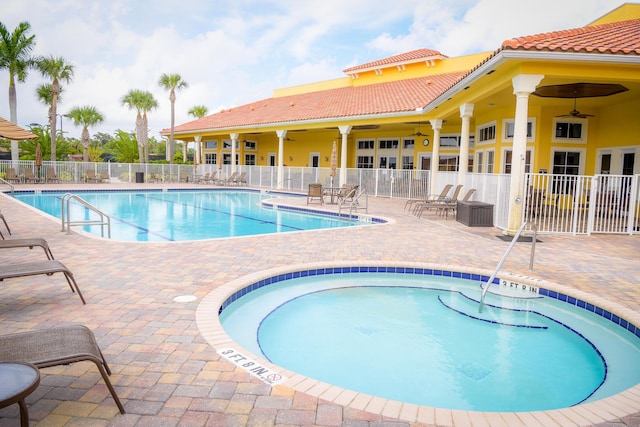 pool with a patio, fence, and a ceiling fan