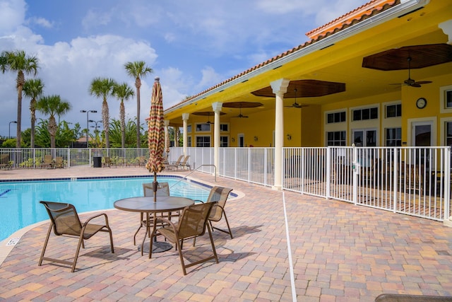 pool featuring fence, ceiling fan, and a patio area
