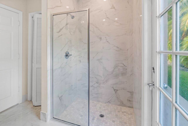 bathroom featuring a closet, marble finish floor, a marble finish shower, and a wealth of natural light