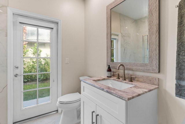 bathroom featuring vanity, toilet, and a marble finish shower