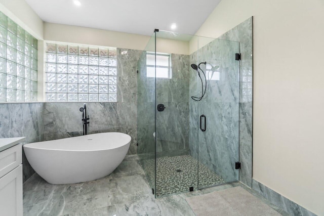 bathroom featuring vanity, a freestanding tub, a stall shower, and marble finish floor