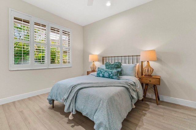bedroom featuring baseboards, ceiling fan, and wood finished floors