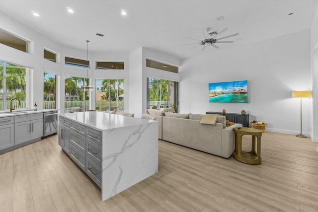 kitchen featuring light wood-style floors, dishwasher, a ceiling fan, open floor plan, and gray cabinetry
