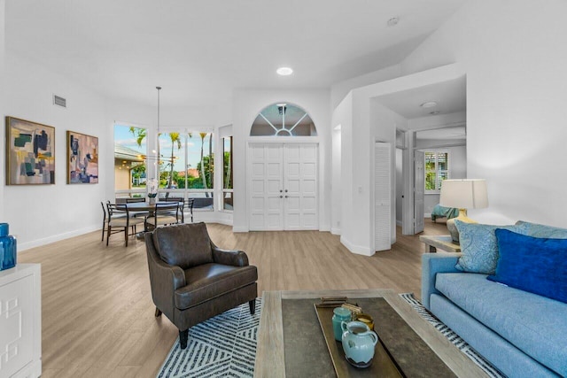 living room with recessed lighting, baseboards, an inviting chandelier, and wood finished floors