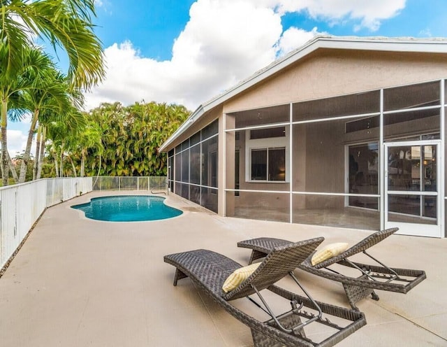 view of pool featuring a fenced in pool, fence, a sunroom, and a patio area