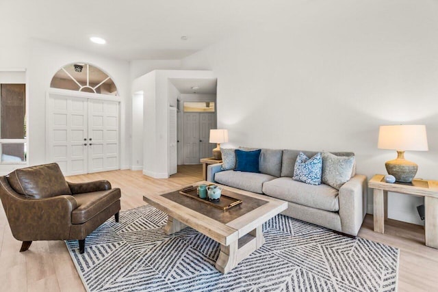 living room featuring baseboards, recessed lighting, and light wood finished floors