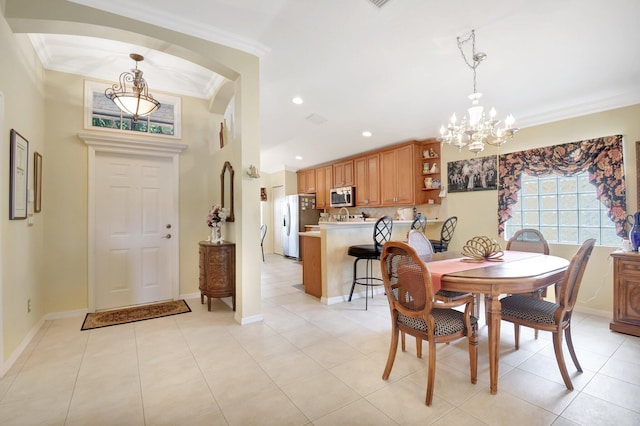 dining space with crown molding, a chandelier, arched walkways, light tile patterned floors, and baseboards
