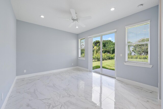 empty room featuring baseboards, ceiling fan, and marble finish floor