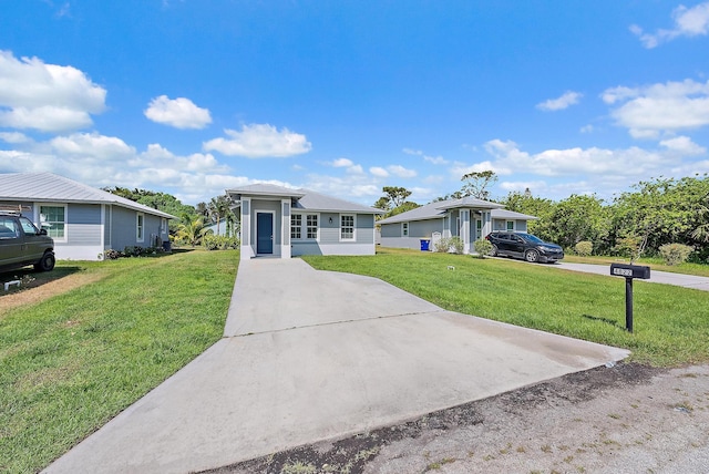 view of front facade with concrete driveway and a front yard