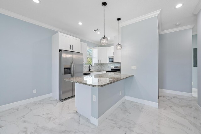 kitchen with crown molding, appliances with stainless steel finishes, light stone countertops, a sink, and baseboards