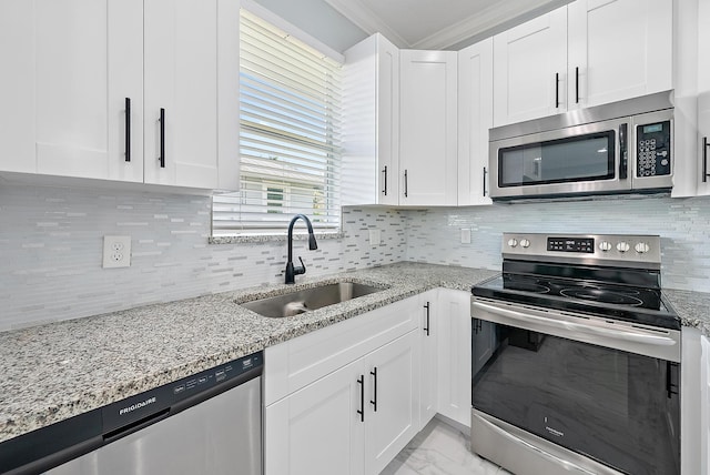 kitchen with crown molding, white cabinets, a sink, marble finish floor, and stainless steel appliances
